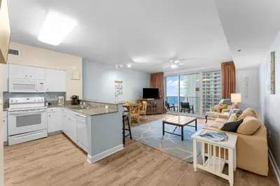 a kitchen and living room with a couch and a table at Shores Of Panama #1224 in Panama City Beach
