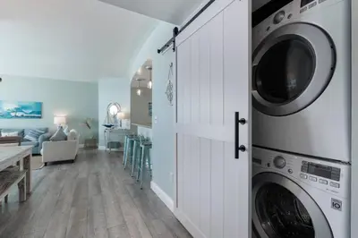 a kitchen and living room with a washer and dryer at Aqua 511 in Panama City Beach