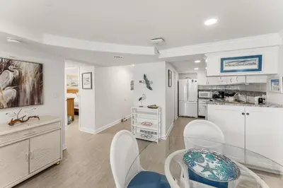 a kitchen with white cabinets and a dining room at Beautiful Beach Front Paradise at Pinnacle Port B2-608! in Panama City Beach