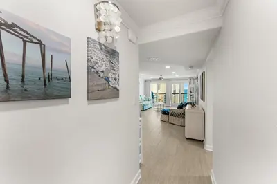 a hallway with three paintings on the walls at Beautiful Beach Front Paradise at Pinnacle Port B2-608! in Panama City Beach