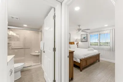 a bedroom with a bed and a bathroom at Beautiful Beach Front Paradise at Pinnacle Port B2-608! in Panama City Beach