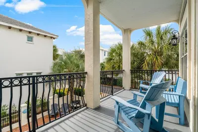 two blue chairs on a porch with the ocean at Coastal Vue in Seacrest