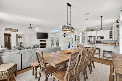 a kitchen and living room with a wooden table and chairs at Coastal Vue in Seacrest