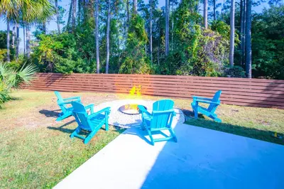 a group of blue chairs sitting around a fire pit at Panhandle Paradise, Heated Pool, Hot Tub, Mini & Disc Golf, Game Room in Panama City Beach