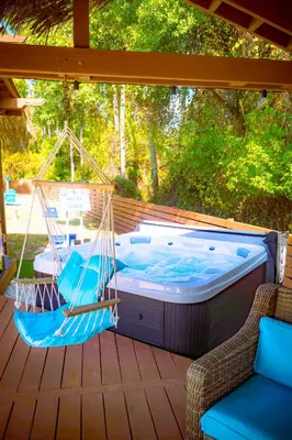 a hammock and chairs on a deck with a hot tub at Panhandle Paradise, Heated Pool, Hot Tub, Mini & Disc Golf, Game Room in Panama City Beach
