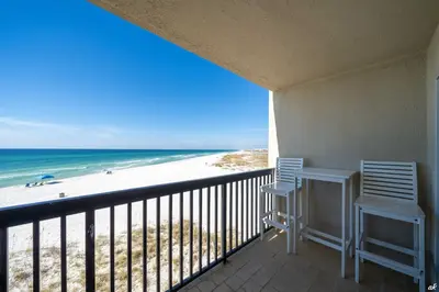 a balcony with two chairs and a view of the beach at Sandy Bottoms PPC3 - 401! Gulf Front Views! in Panama City Beach