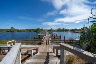a wooden dock with benches on a lake at Sandy Bottoms PPC3 - 401! Gulf Front Views! in Panama City Beach