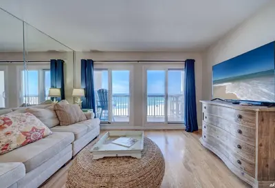 a living room with a couch and a tv at Sandy Bottoms PPC3 - 401! Gulf Front Views! in Panama City Beach