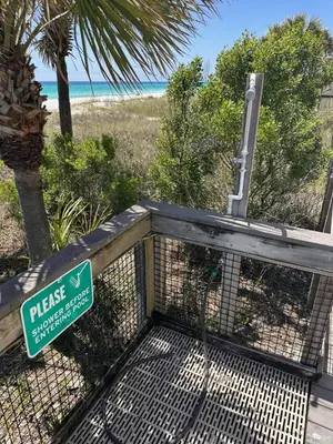 a sign on a fence next to a beach at Toes in the Sand at Shores #101 in Panama City Beach