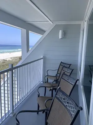 a row of chairs sitting on a balcony with the beach at Toes in the Sand at Shores #101 in Panama City Beach