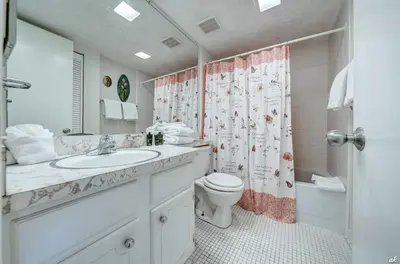 a bathroom with a sink and a toilet and a shower at Toes in the Sand at Shores #101 in Panama City Beach