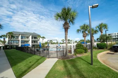 a house with palm trees and a playground at Emerald Hill Unit #15 Gulf Front ground floor in Santa Rosa Beach