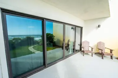a room with large windows and a table and chairs at Emerald Hill Unit #15 Gulf Front ground floor in Santa Rosa Beach