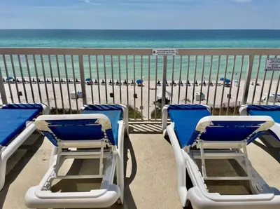 a balcony with blue and white chairs and the beach at Sunrise Beach 2007 in Panama City Beach