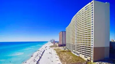a view of a beach with a building and the ocean at Emerald Beach 1835 in Panama City Beach