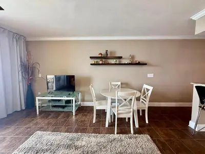 a dining room with a table and chairs and a television at Emerald Beach 1935 in Panama City Beach