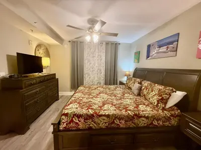 a bedroom with a bed and a flat screen tv at Emerald Beach 1935 in Panama City Beach