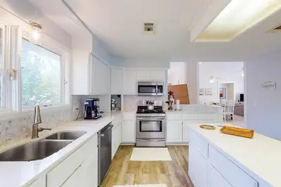 a white kitchen with a sink and a stove at Sandy Shores by Emerald Coast Retreats in Panama City Beach