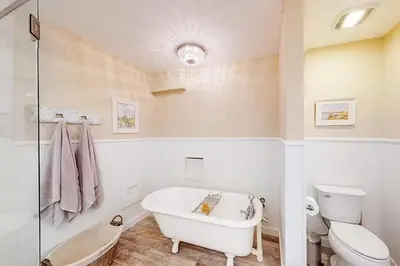 a white bathroom with a tub and a toilet at Sandy Shores by Emerald Coast Retreats in Panama City Beach