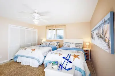 a bedroom with two beds and a ceiling fan at Sandy Shores by Emerald Coast Retreats in Panama City Beach