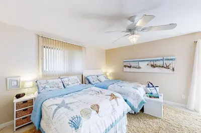 a bedroom with two beds and a ceiling fan at Sandy Shores by Emerald Coast Retreats in Panama City Beach