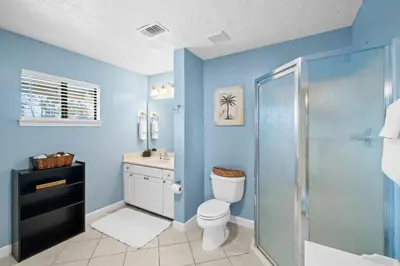 a blue bathroom with a toilet and a shower at Lagoon Cocune by Book That Condo in Panama City Beach