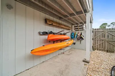 an orange kayak hanging on the side of a building at Lagoon Cocune by Book That Condo in Panama City Beach