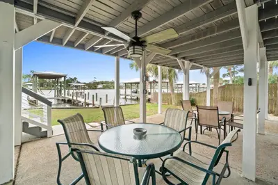 a patio with a table and chairs and a view of the water at Lagoon Cocune by Book That Condo in Panama City Beach