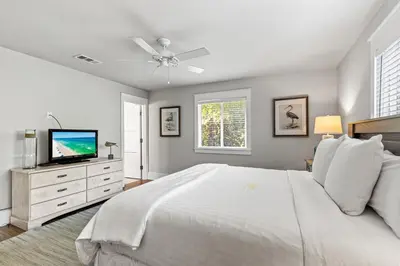a white bedroom with a bed and a tv at Pool On 30A Gulf Views Balconies Luxury in Inlet Beach