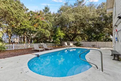 a swimming pool in a yard with chairs and a fence at Pool On 30A Gulf Views Balconies Luxury in Inlet Beach