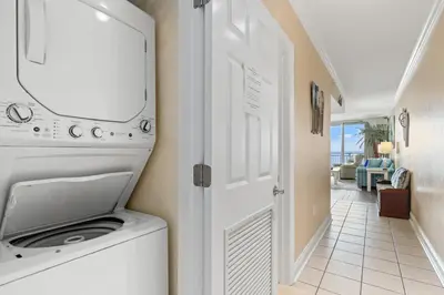a washer and dryer in a room with a hallway at Emerald Beach Resort 234 | Roo’s Rendezvous in Panama City Beach