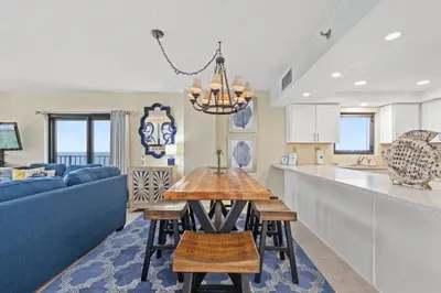 a kitchen and living room with a table and a blue couch at Watercrest 1110 - Sunset Haven in Panama City Beach