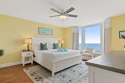 a bedroom with a bed and a large window at Emerald Beach Resort 1431 | Tucker’s Tondo in Panama City Beach