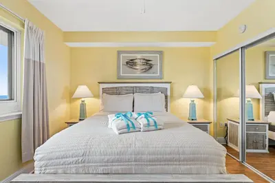a bedroom with a bed with two pillows on it at Emerald Beach Resort 1431 | Tucker’s Tondo in Panama City Beach