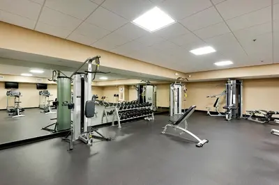 a gym with treadmills and machines in a room at Emerald Beach Resort 1431 | Tucker’s Tondo in Panama City Beach