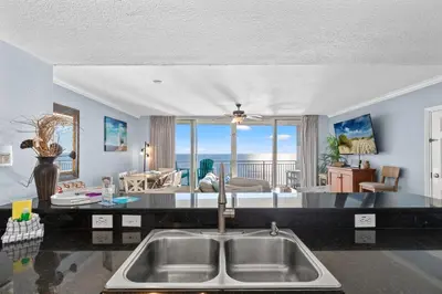 a kitchen and living room with a view of the ocean at Emerald Beach Resort 2028 in Panama City Beach