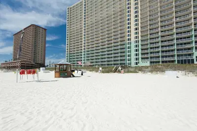 a sandy beach with tall buildings in the background at Emerald Beach Resort 2028 in Panama City Beach