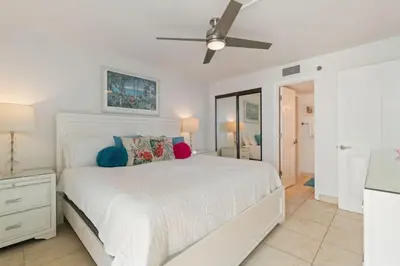 a white bedroom with a bed and a ceiling fan at NEW 30A Beachfront Condo with Pool and 4 Beds with Gulf Views in Santa Rosa Beach
