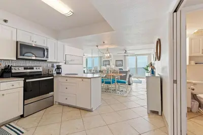 a kitchen with white cabinets and a dining room at NEW 30A Beachfront Condo with Pool and 4 Beds with Gulf Views in Santa Rosa Beach