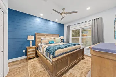 a bedroom with a bed and a blue wall at Fun Beach Condo on 30A with POOL and Lake and Beach Access in Santa Rosa Beach