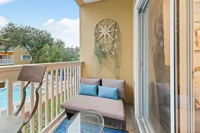 a balcony with a chair and a table at Fun Beach Condo on 30A with POOL and Lake and Beach Access in Santa Rosa Beach