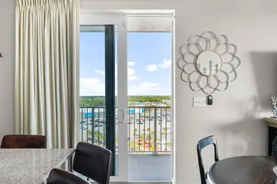 a dining room with a table and chairs and a balcony at Laketown Wharf #0938 in Panama City Beach