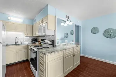 a kitchen with white cabinets and blue walls at The Summit 408 in Panama City Beach
