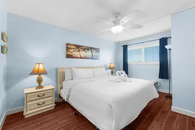 a bedroom with a large white bed and a night stand at The Summit 408 in Panama City Beach