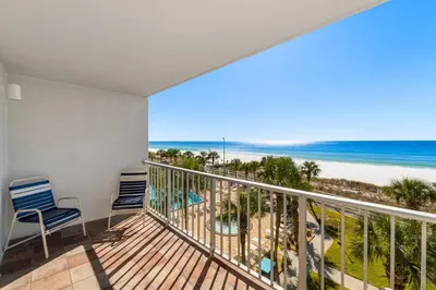 a balcony with two chairs and a view of the beach at The Summit 408 in Panama City Beach