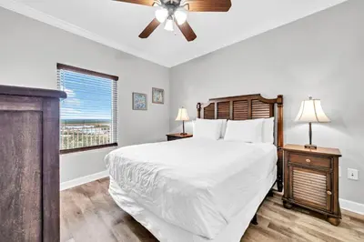 a bedroom with a bed and a ceiling fan at Splash 1803W in Panama City Beach