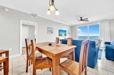a dining room and living room with a table and chairs at Splash 1803W in Panama City Beach