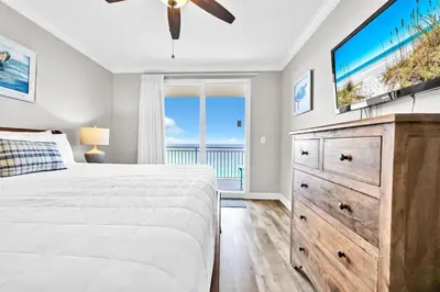 a bedroom with a large bed and a flat screen tv at Splash 1803W in Panama City Beach