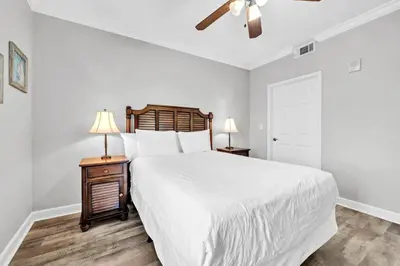 a bedroom with a large white bed and two lamps at Splash 1803W in Panama City Beach