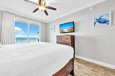 a bedroom with a bed and a ceiling fan at Splash 1803W in Panama City Beach